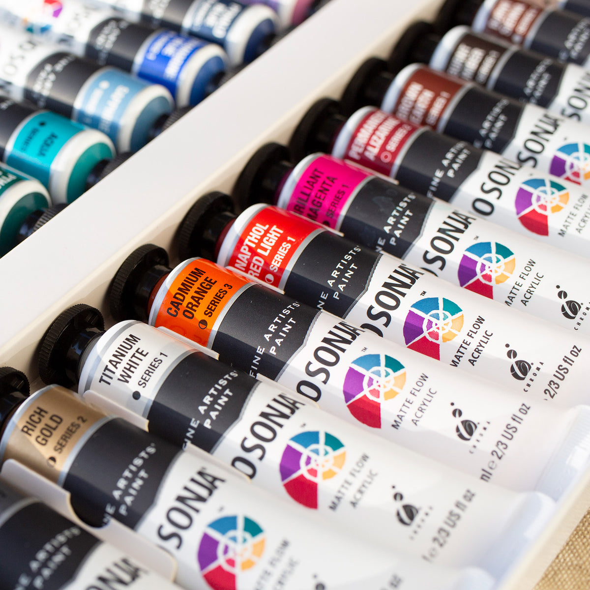 Rows of Jo Sonja's 75ml tubes lined up in a box, range photo shown with Burnt Sienna