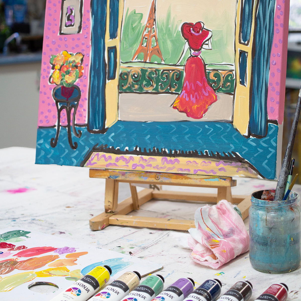 Painting of a woman at a window on a small easel with Jo Sonja's tubes, range photo shown with Colony Blue