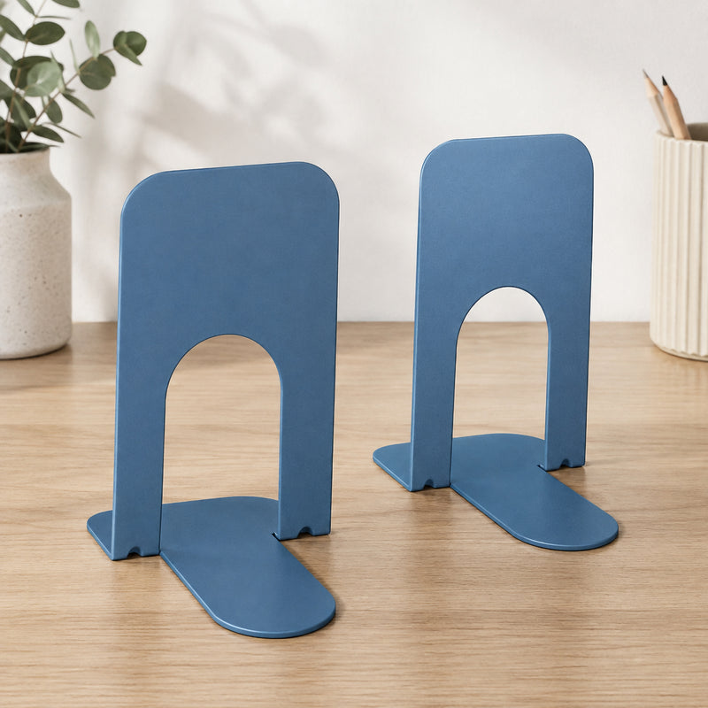 Pair of KW by Colby Student Bookends in slate blue displayed individually on a timber surface. The image clearly shows their tall rounded panels, open lower sections and broad flat bases, providing a useful view of the compact design used to support books and study materials.