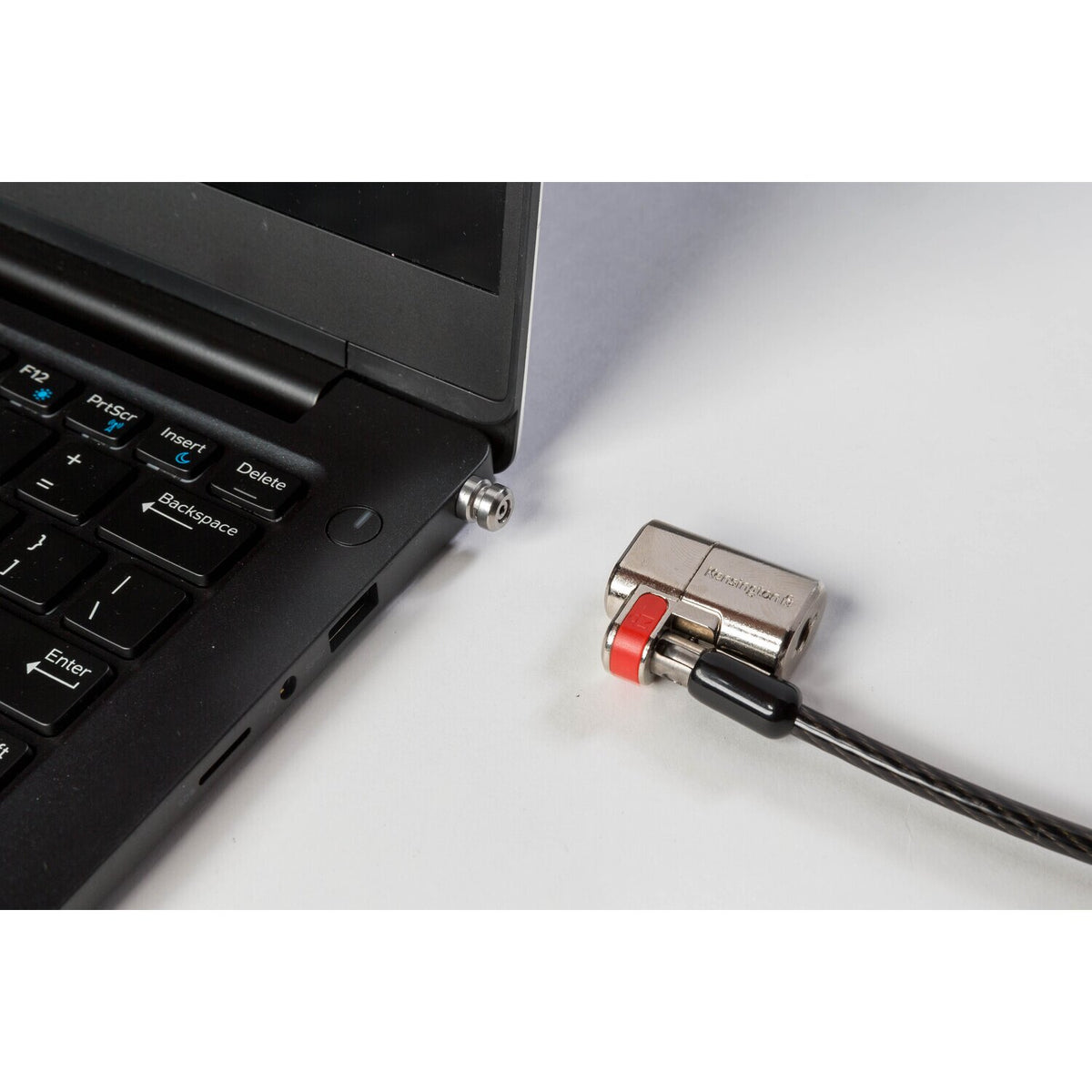Kensington ClickSafe wedge anchor fitted in the side slot of a black laptop, with a ClickSafe lock head beside it