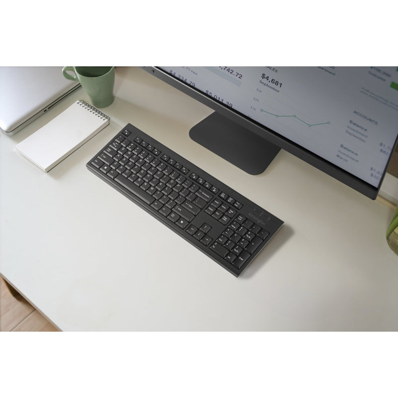 Kensington KB270 EQ Keyboard in black, overhead view on a desk in front of a monitor stand