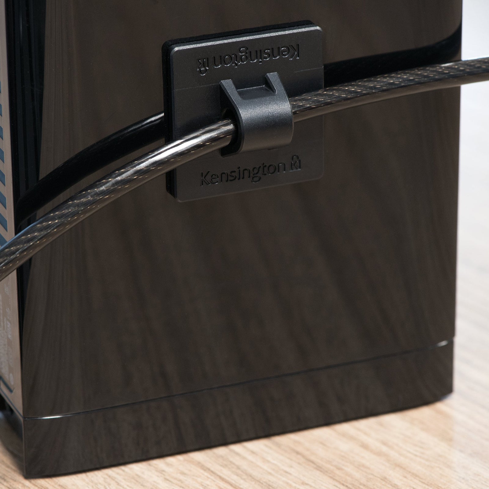 Rear view of an attached cable management anchor showing secure routing of the carbon steel security cable. The image illustrates neat installation and effective theft prevention.