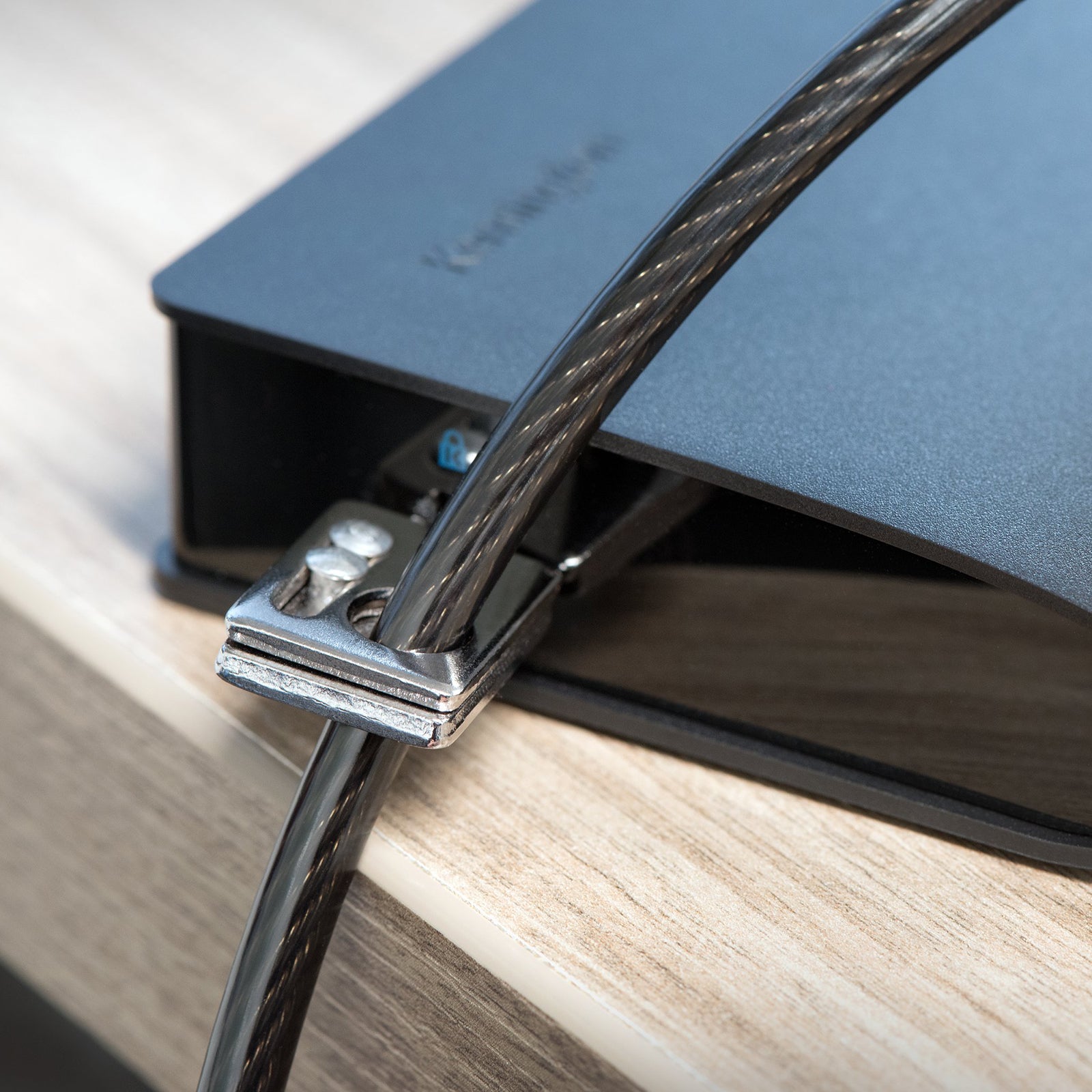 Close up of the anchor plate securing a cable to a docking station or device. The image highlights compatibility with equipment that may not include a standard Kensington security slot.