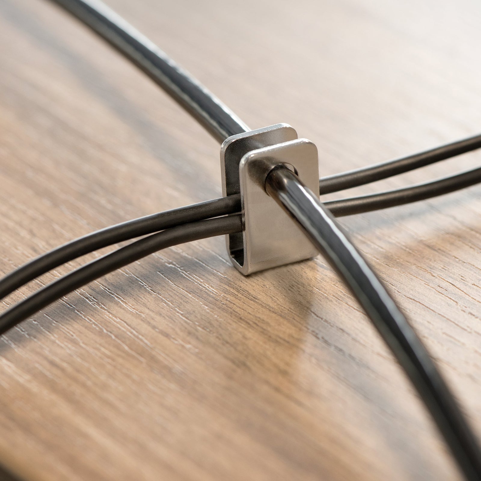 Detailed image of the cable trap component securing multiple cables together. The accessory demonstrates how additional peripherals can be protected within a single integrated security solution.