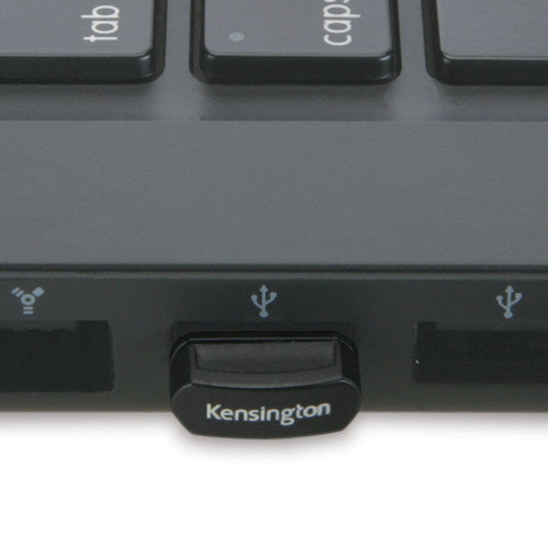 Kensington nano USB receiver plugged into the side USB port of a laptop beside the keyboard