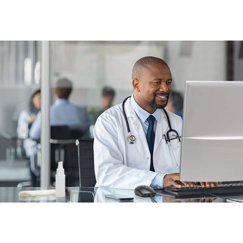 Clinician in a white coat working at a desktop computer with a Kensington Pro Fit washable mouse on the desk