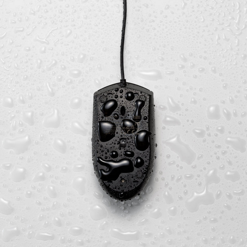 Black Kensington Pro Fit washable mouse lying on a wet surface with water droplets beaded across the shell