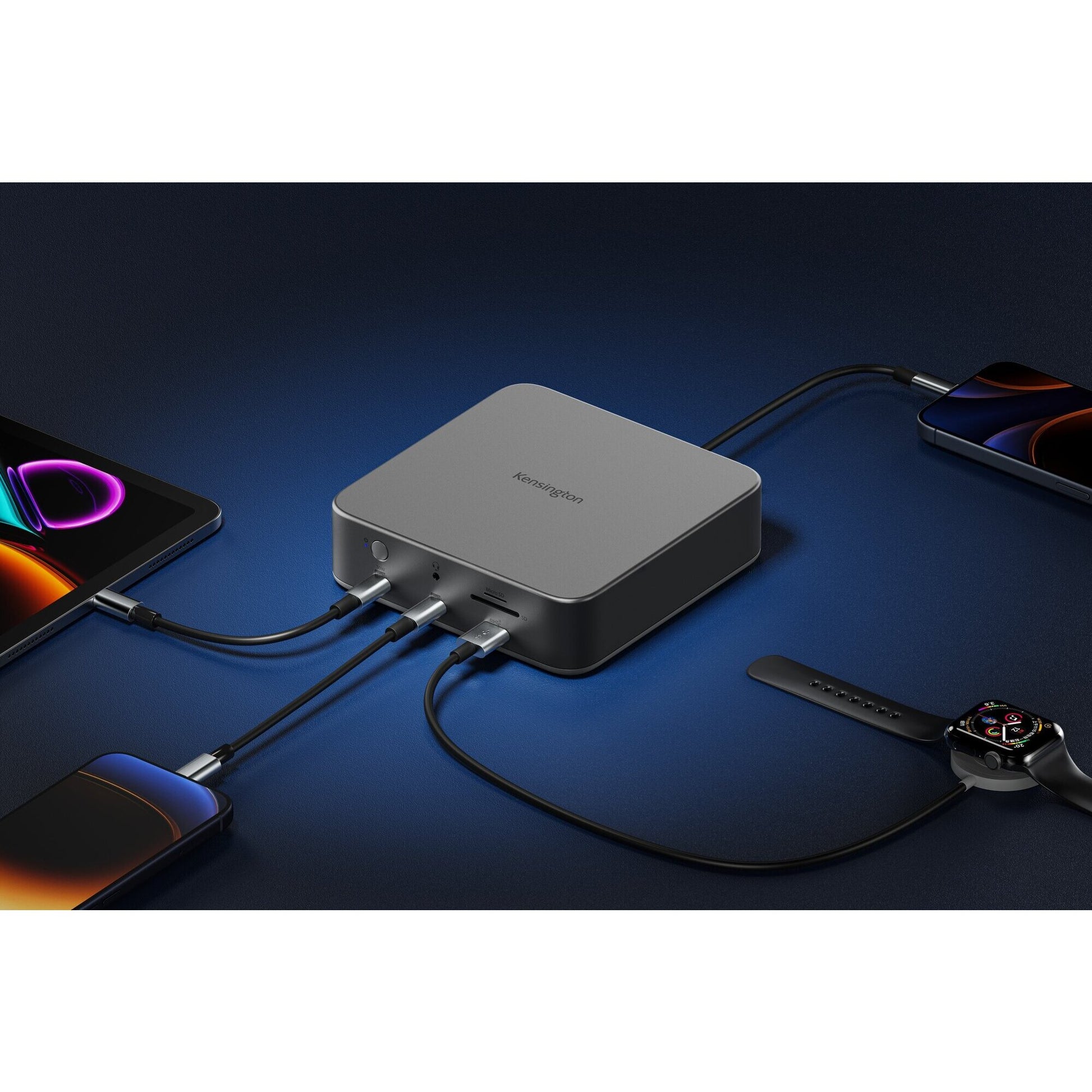 Kensington SD5010T5 docking station on a dark desk charging a phone, smartwatch and tablet while connected to a laptop