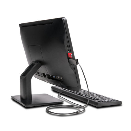 Rear of an all-in-one computer with a red Kensington USB port blocker fitted in a side port and a cable running down towards the keyboard