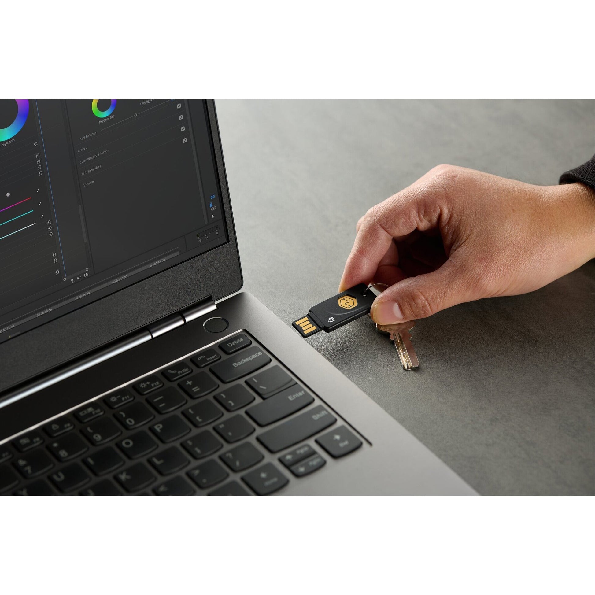 Scale view of the Kensington VeriMark NFC Plus security key alongside a hand, showing the compact size of the token