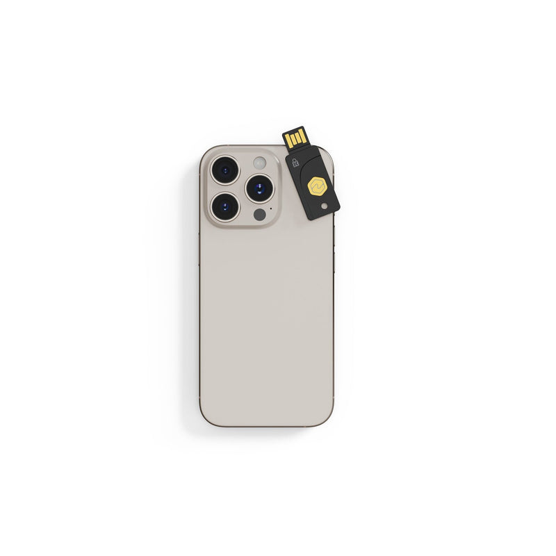 Kensington VeriMark NFC Plus security key shown inserted into a USB-A port on a laptop, illustrating hardware based multifactor sign in