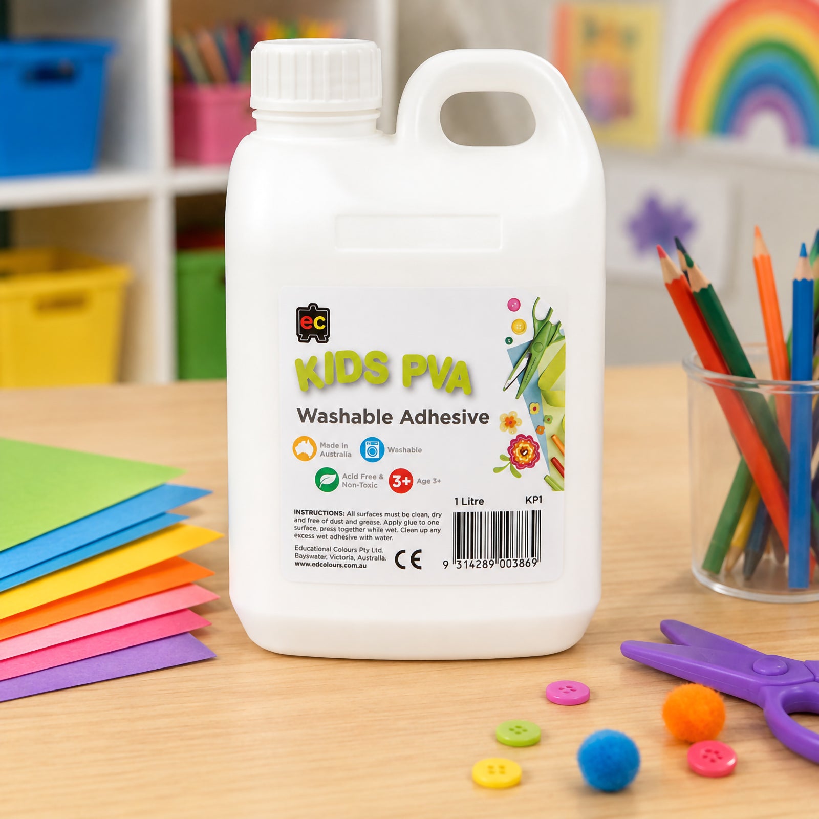 Educational Colours Kids Washable PVA Glue 1 Litre showcased on a craft table with coloured paper, pencils, buttons and pom poms. The bright classroom setting demonstrates its versatility for arts and crafts, model making, collage work and educational creative projects.