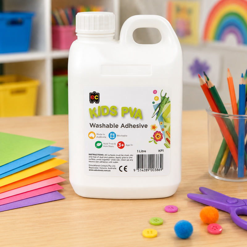 Educational Colours Kids Washable PVA Glue 1 Litre showcased on a craft table with coloured paper, pencils, buttons and pom poms. The bright classroom setting demonstrates its versatility for arts and crafts, model making, collage work and educational creative projects.