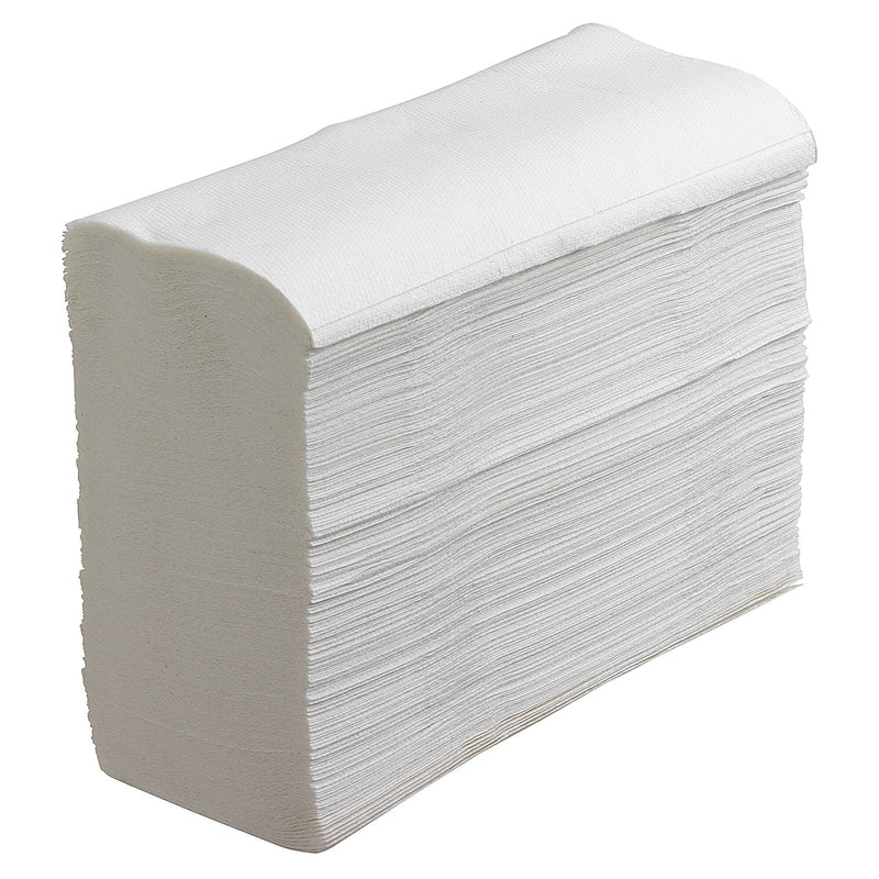 Unwrapped stack of white Kleenex compact hand towels on a plain background, showing the interleaved fold and the embossed texture across the top sheet