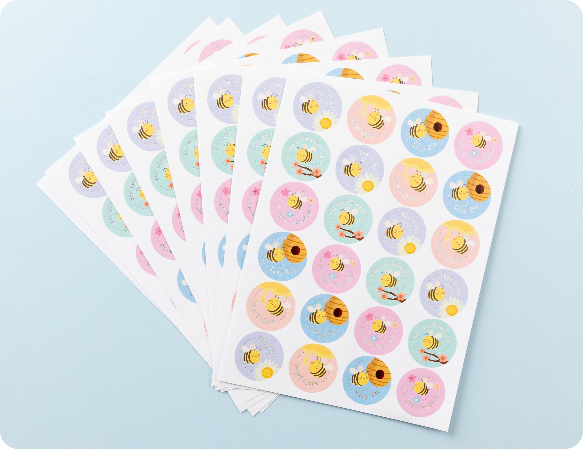 Sticker sheets from the Bee-utiful Rewards book fanned out to show the bee designs and encouragement wording.