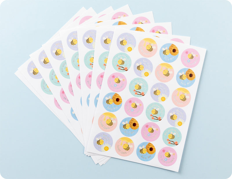 Sticker sheets from the Bee-utiful Rewards book fanned out to show the bee designs and encouragement wording.