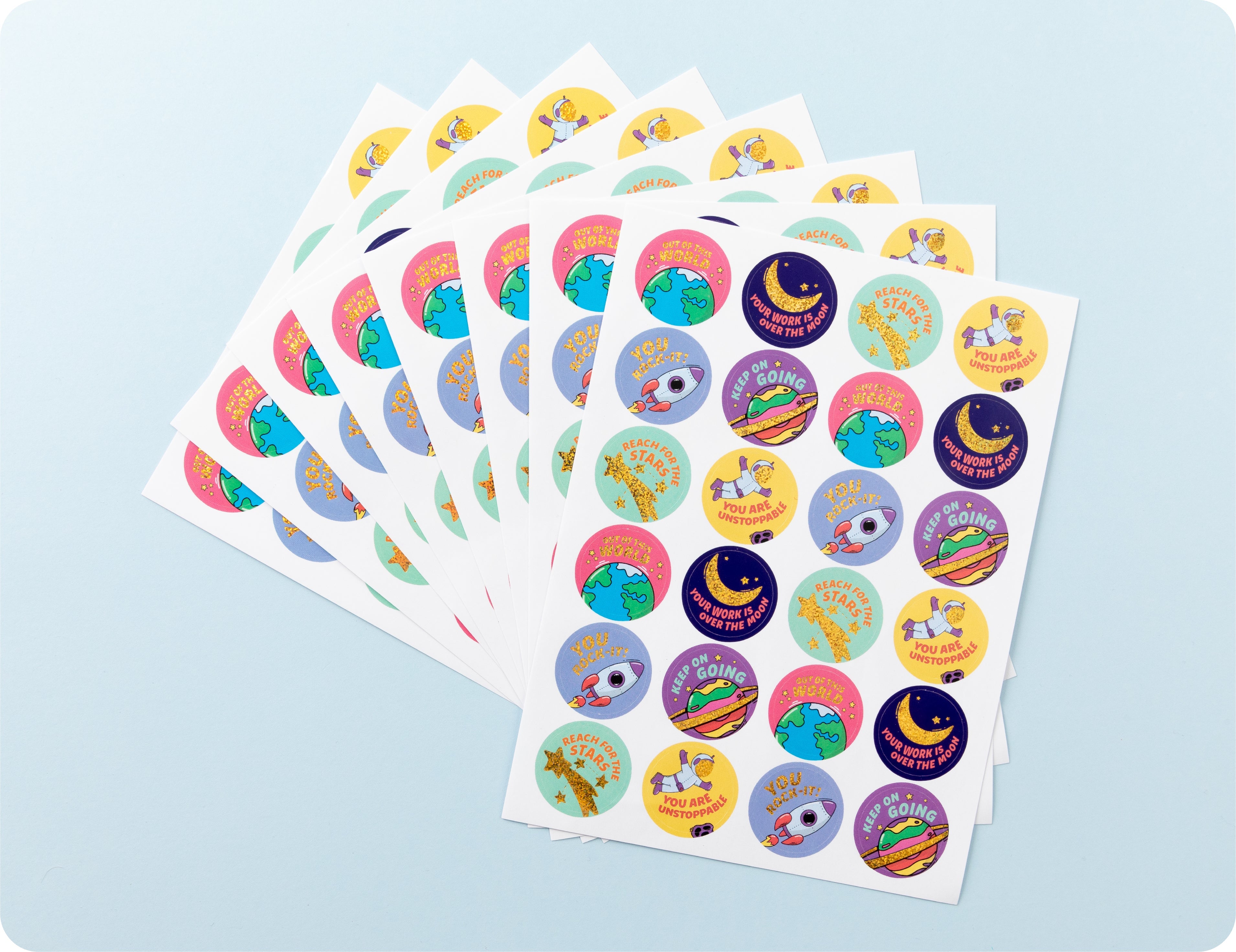 Sticker sheets from the Galactic Greatness book fanned out to show the space designs and encouragement wording.