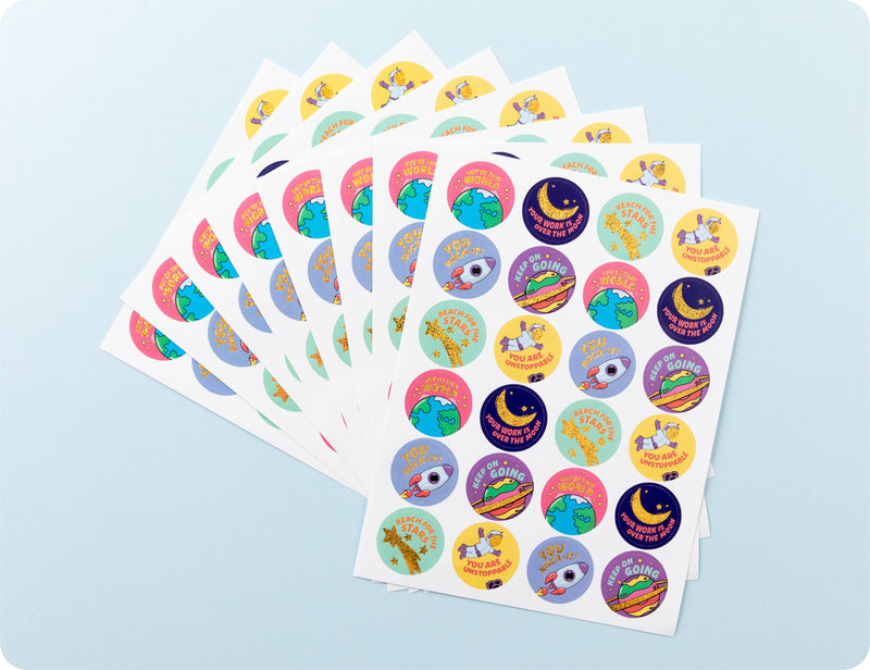 Sticker sheets from the Galactic Greatness book fanned out to show the space designs and encouragement wording.