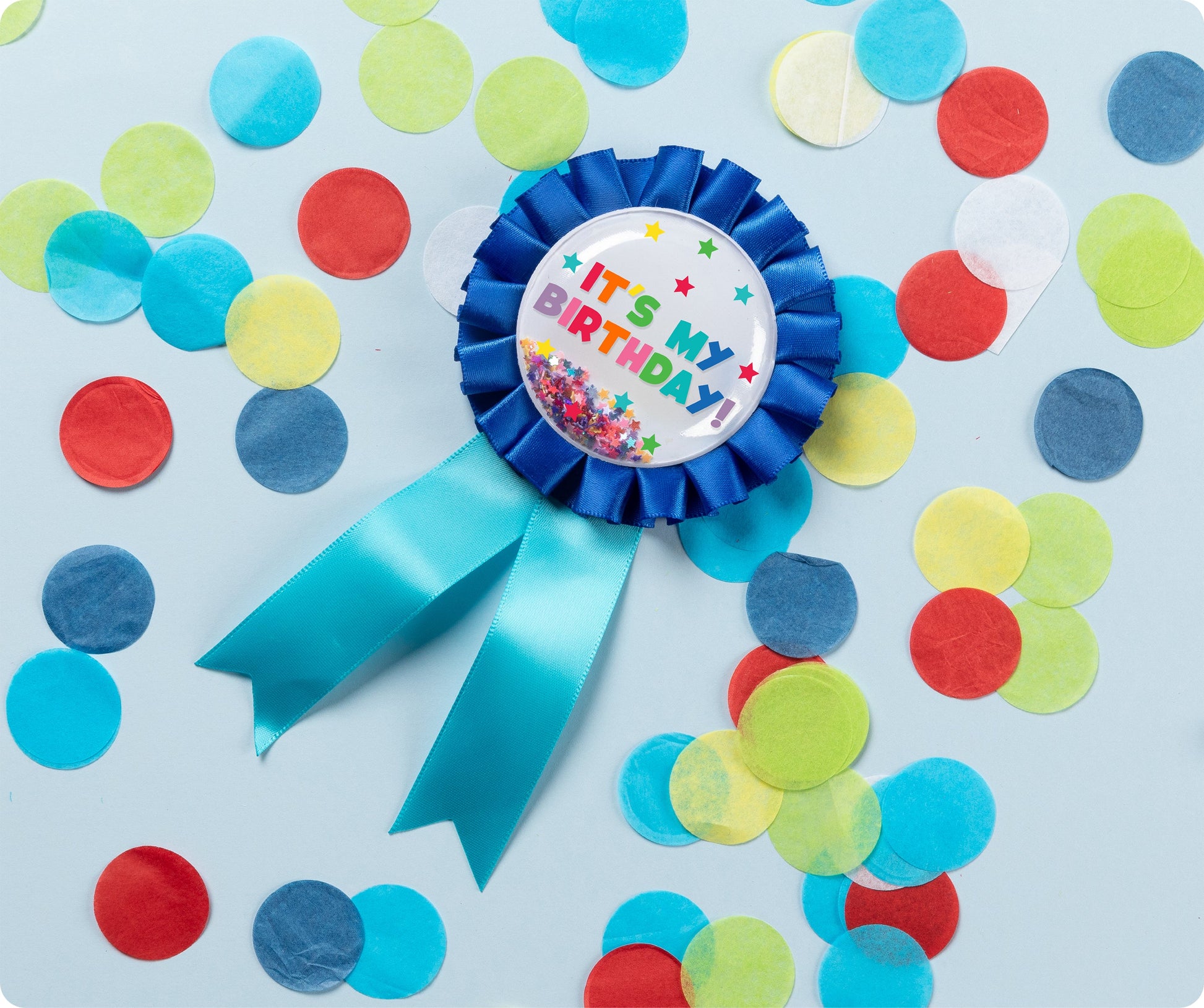 Blue Giggle and Grow birthday badge with a happy birthday message and loose metallic confetti visible inside the clear front pocket.