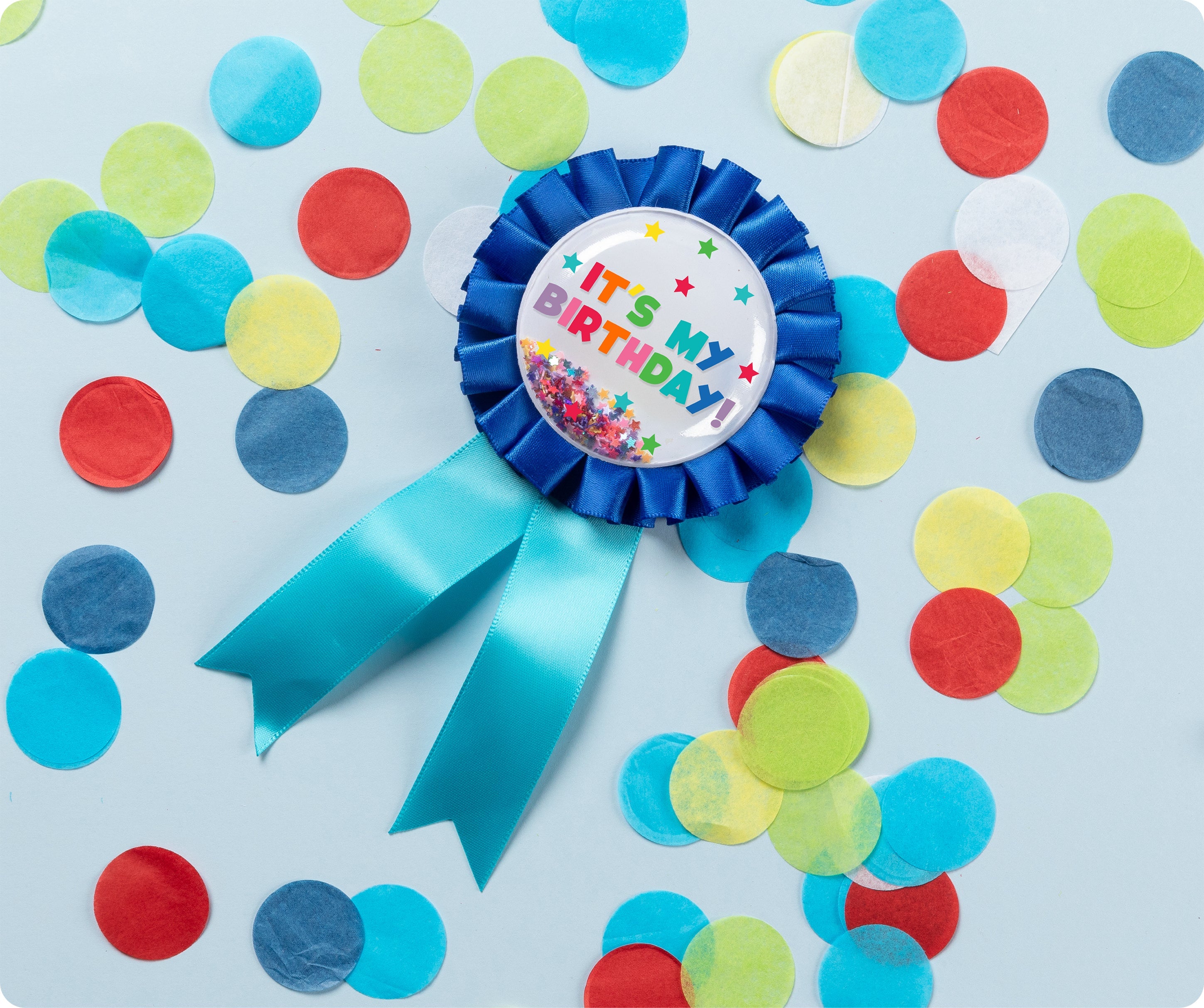 Blue Giggle and Grow birthday badge with a happy birthday message and loose metallic confetti visible inside the clear front pocket.