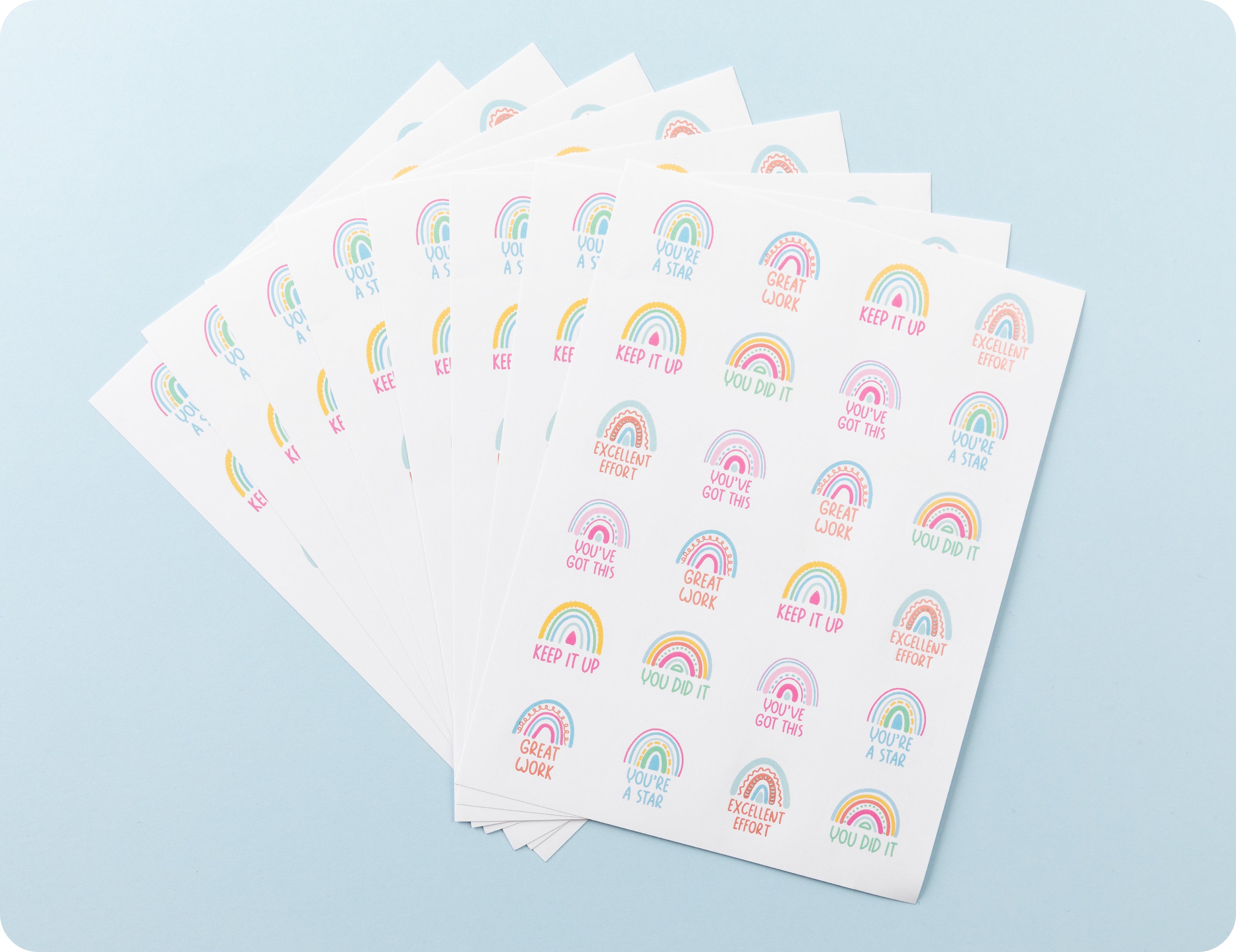 Sticker sheets from the Rainbow Rewards book fanned out to show the rainbow designs and message wording.