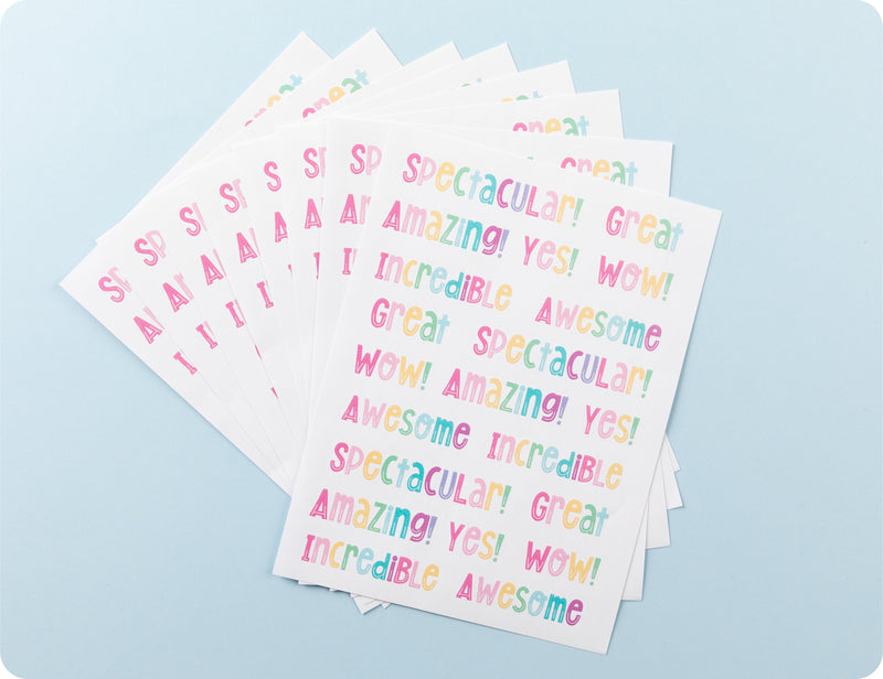 Sticker sheets from the Rainbow Shoutouts book fanned out to show the range of praise words across the sheets.