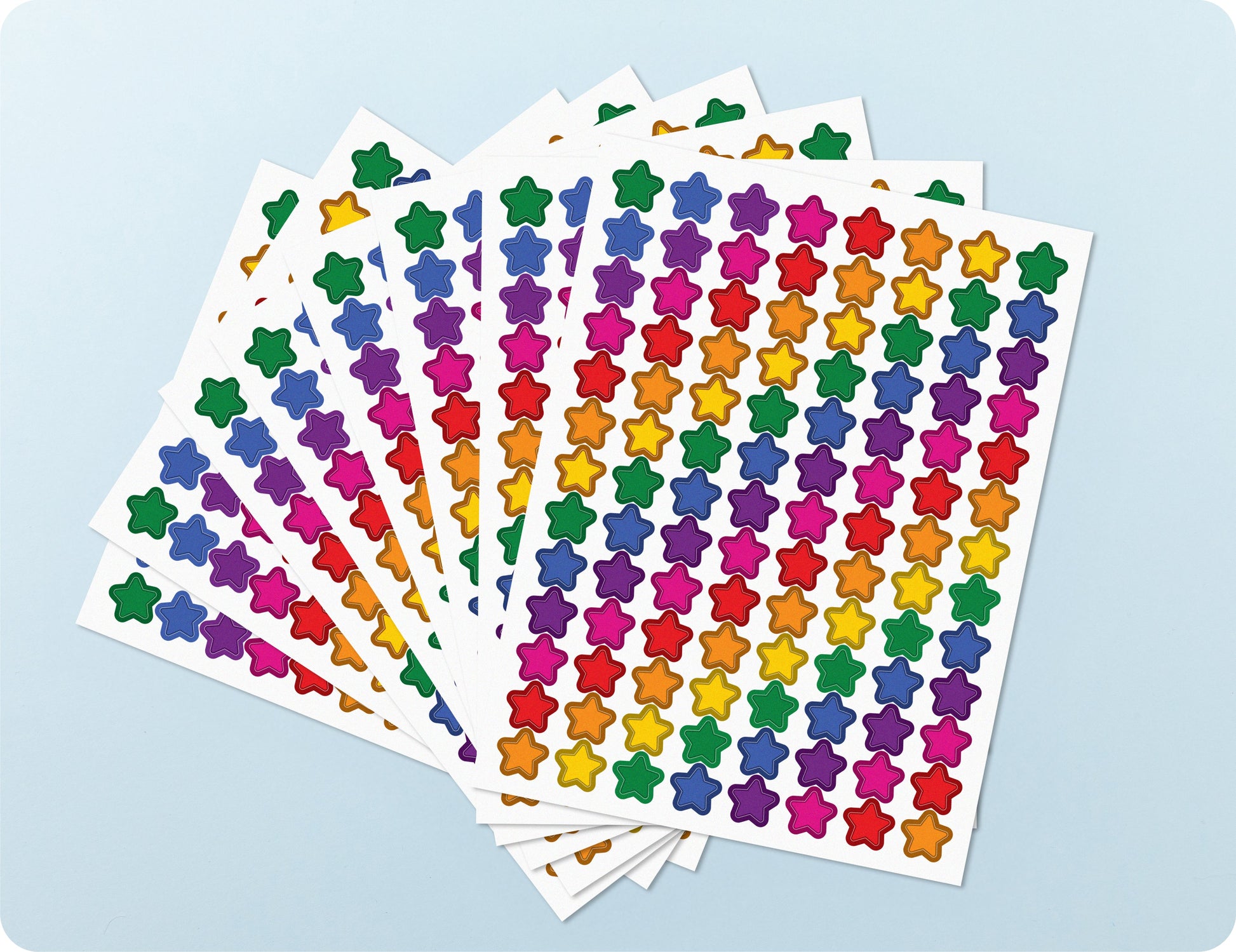 Sticker sheets from the Rainbow Sparkle book fanned out to show the density of small glitter stars per sheet.