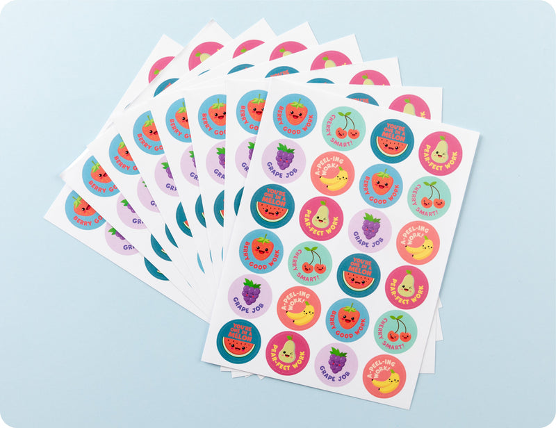 Sticker sheets from the Tutti Frutti Triumphs book fanned out to show the fruit designs and wordplay phrases.