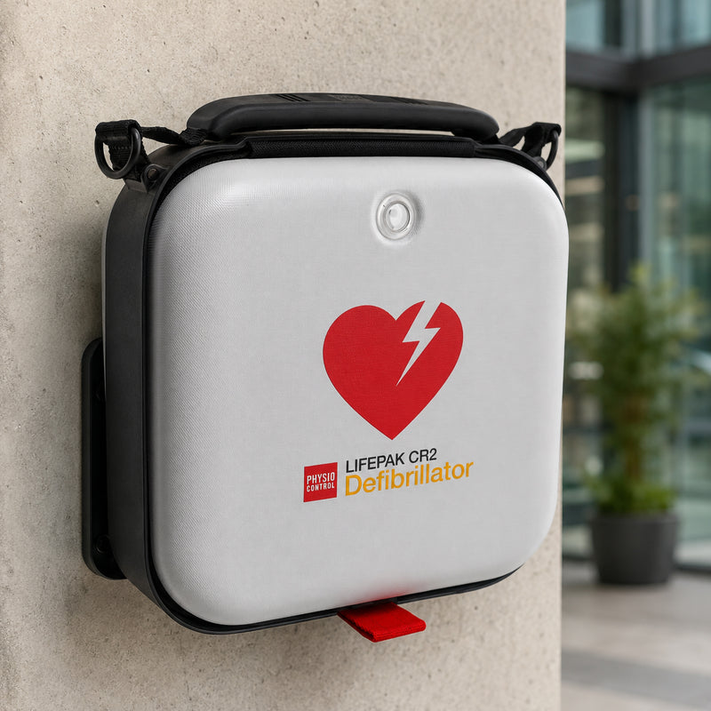 The LifePak CR2 Semi Automatic Defibrillator is securely mounted on a wall in its protective carry case, ready for immediate access in a commercial building. The installation demonstrates convenient workplace emergency preparedness and rapid accessibility.