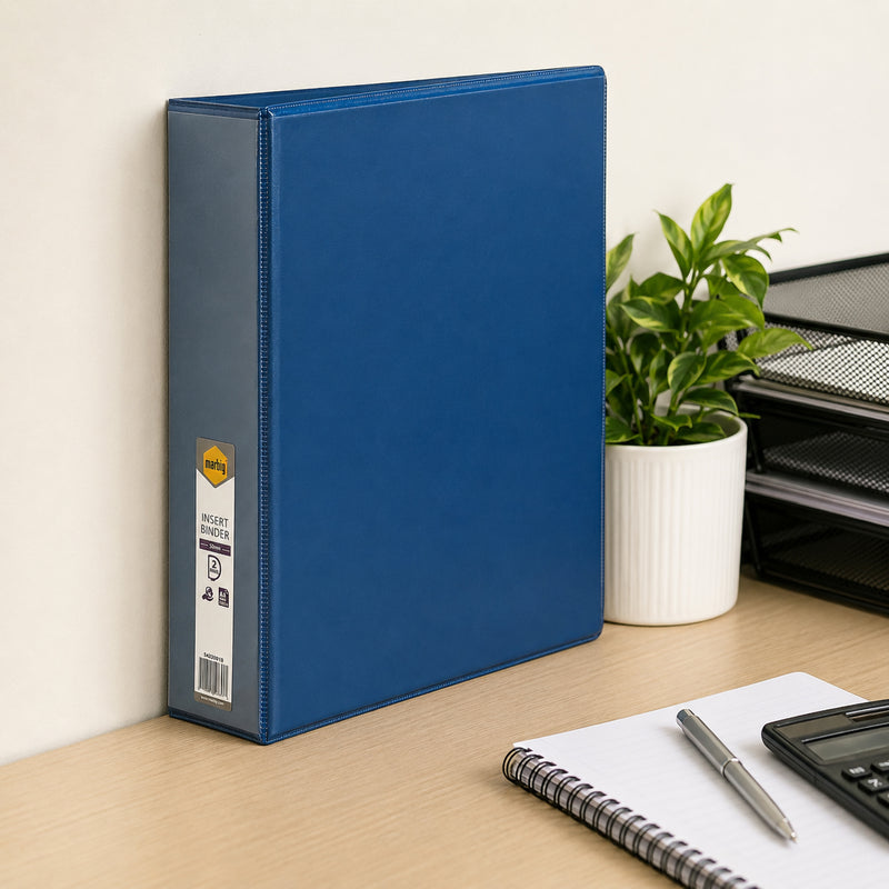 Marbig Clearview A4 50mm Blue Insert Binder standing upright against an office wall beside a plant, notebook and desk organiser, illustrating practical desktop document storage in a modern workplace.