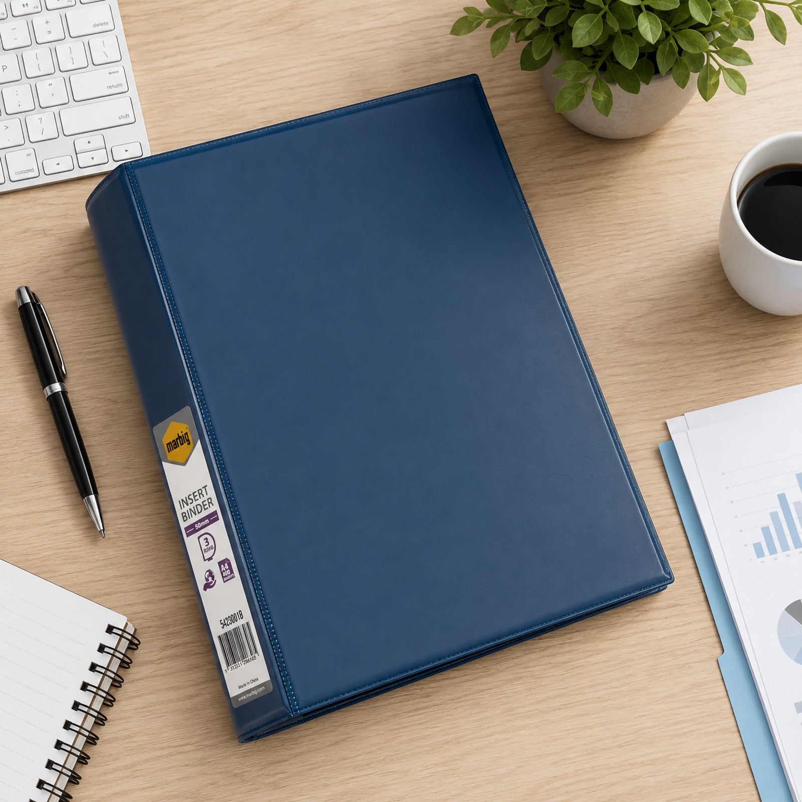 Top down view of the Marbig Clearview A4 50mm 3D Ring Blue Binder positioned on a timber office desk with keyboard, stationery, coffee and business reports, highlighting the durable cover and clean professional finish.