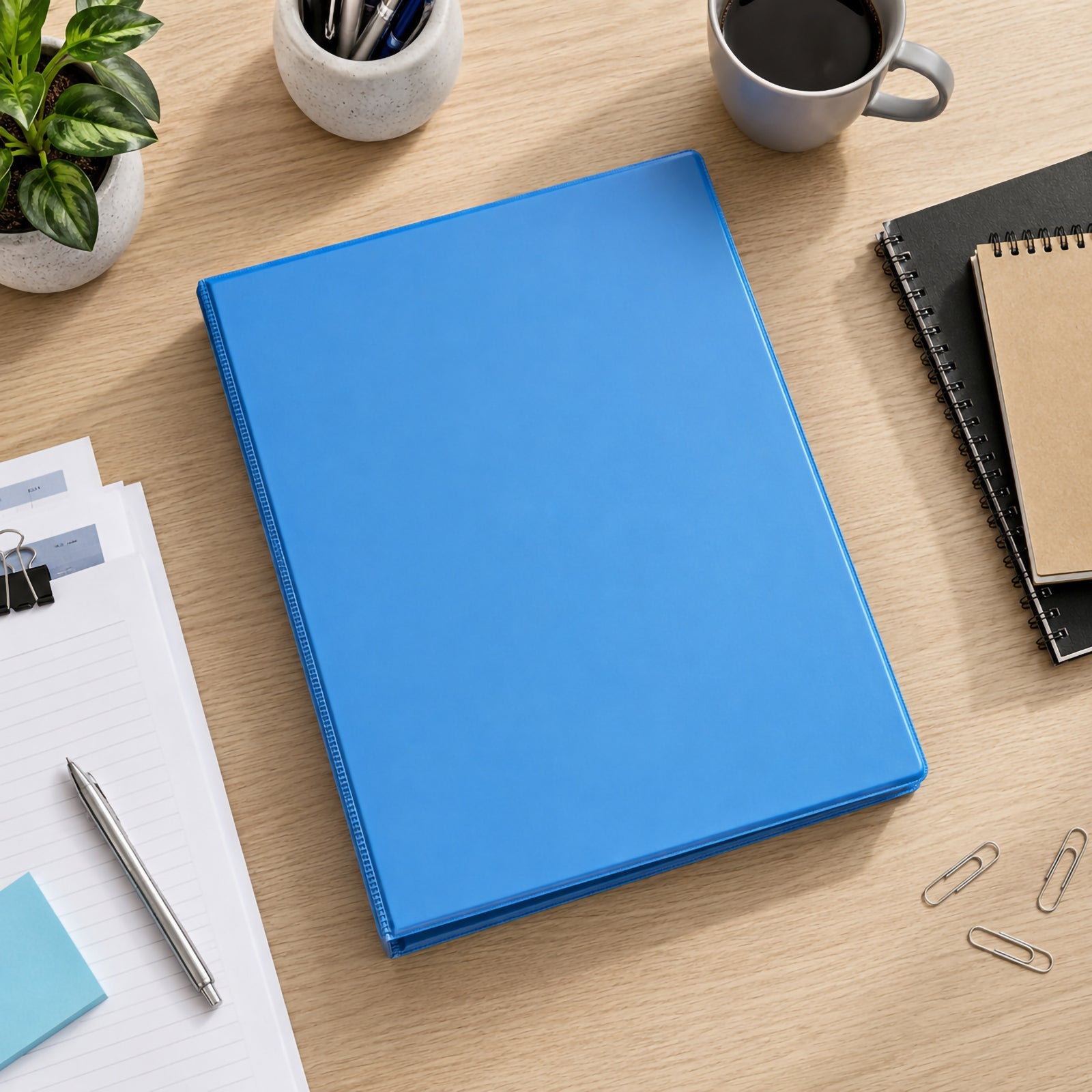 Top view of the Marbig Marine Clearview A4 50mm 4D Ring Binder positioned on a timber desk surrounded by stationery, coffee, notebooks and paperwork, highlighting its vibrant finish and professional appearance.