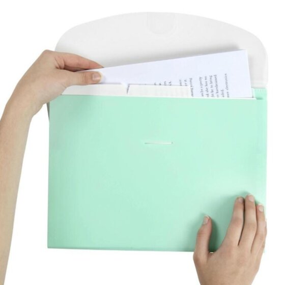 Hand lifting pages behind a tab in a Marbig pastel green expanding wallet with the white flap folded back