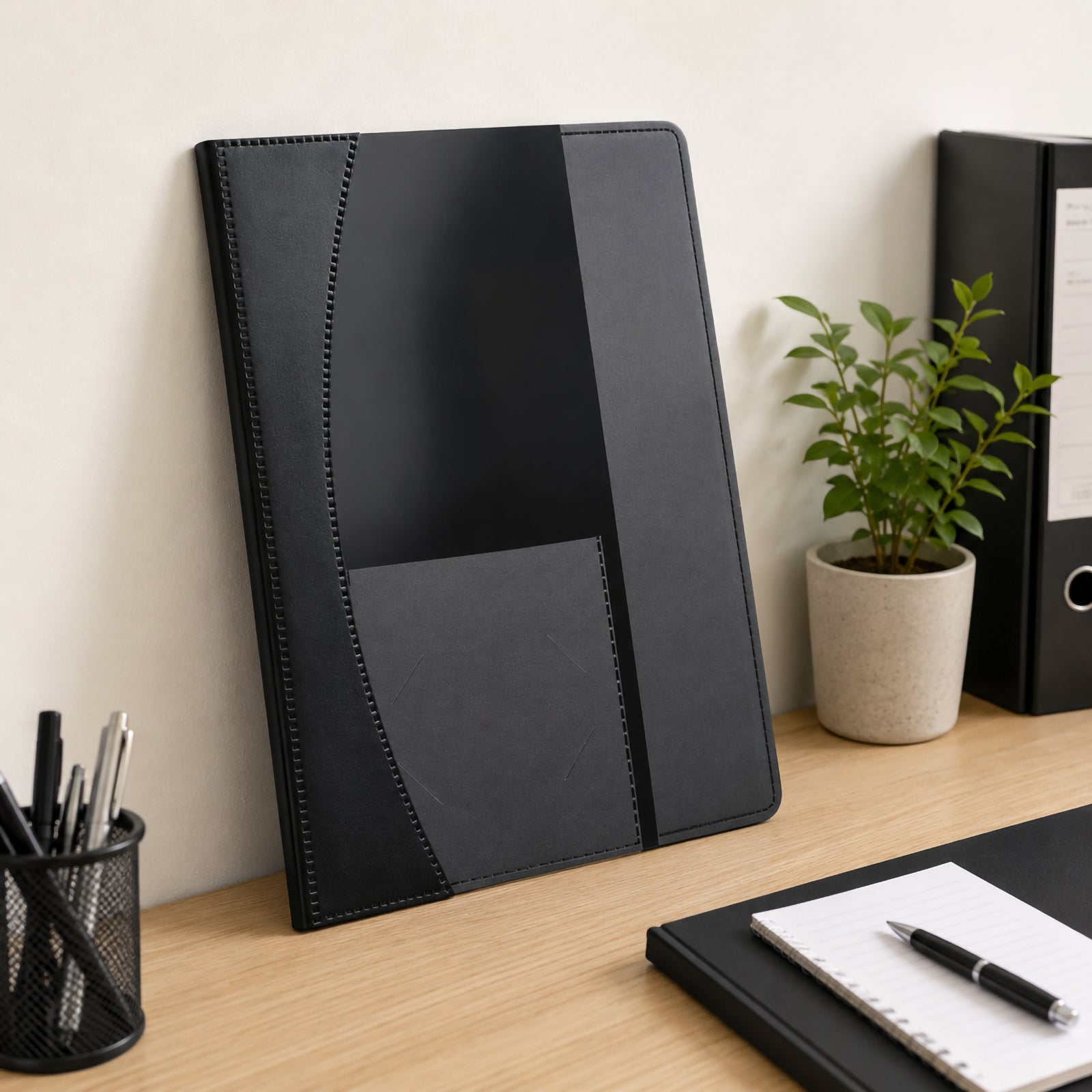 Marbig Premier Flat File standing upright against an office wall beside stationery and folders, displaying its elegant black exterior and modern professional appearance.