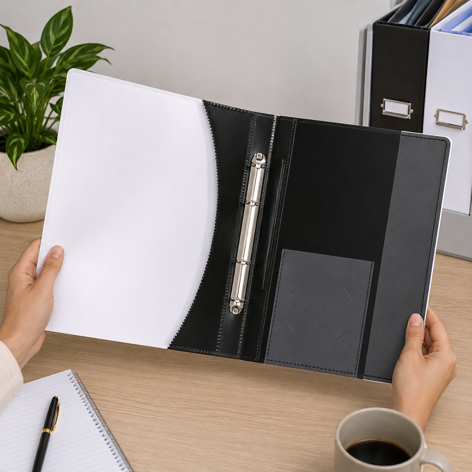 Hands opening the Marbig Premier Flat File A4 Black on an office desk, showcasing the secure two prong fastener, vertical document pocket, business card holder and premium interior layout designed for organised presentations.
