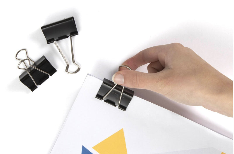 Marbig 41mm fold back clip in use fastening a document, with a hand fitting the clip and two spare clips