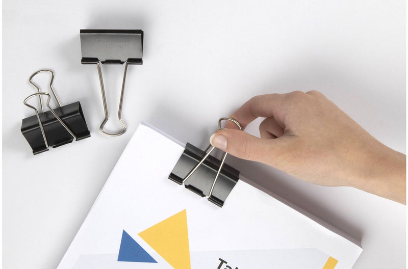 Marbig 50mm fold back clip in use fastening a thick document, with a hand fitting the clip and spare clips nearby
