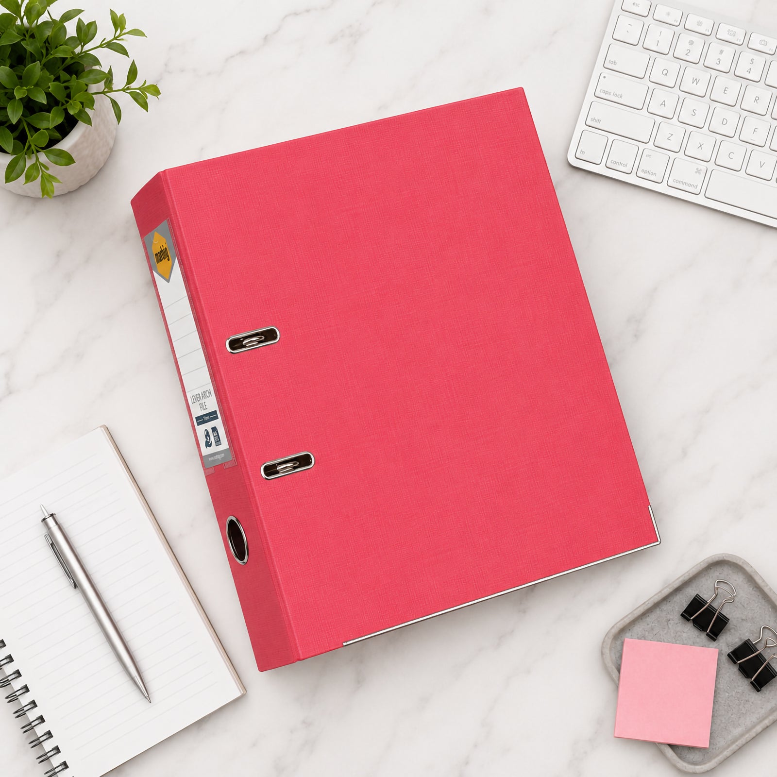 Top view of the Marbig A4 Coral Lever Arch File placed on a marble desk with stationery, keyboard and office accessories, showcasing its premium linen finish and stylish workspace organisation.