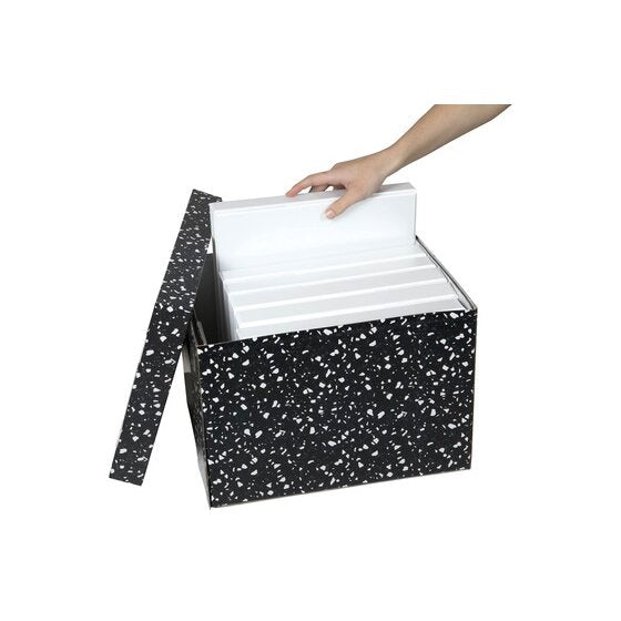 Hand lowering white ring binders into an open Marbig terrazzo archive box with the speckled lid propped open