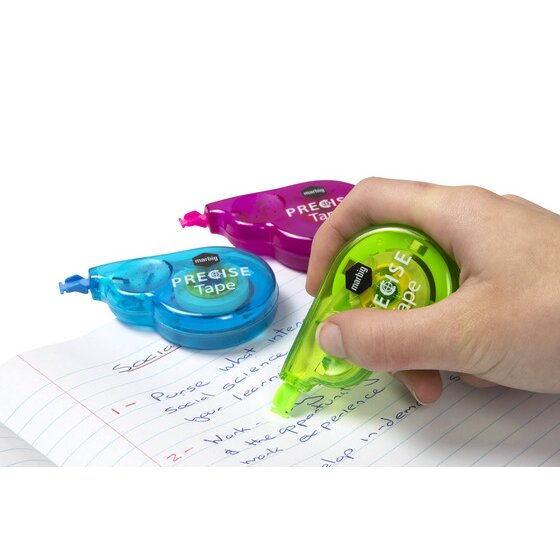 Hand holding a green Marbig Precise correction tape against handwritten notes on lined paper, blue and pink tapes behind