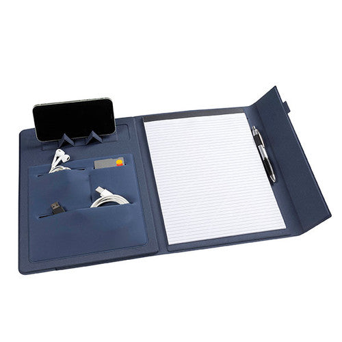 The navy blue Marbig 9000844 compendium open, with a phone upright in the fold out stand, earphones, cables and a card in the pouches, a lined pad and a pen in the loop