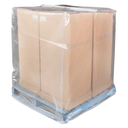 Tall stack of cardboard cartons on a blue pallet covered by a clear plastic pallet bag reaching down to the pallet base