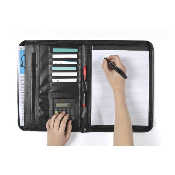 Hands writing on the pad and using the calculator inside the open black Marbig R90087 pad holder, with cards in the slots on the left