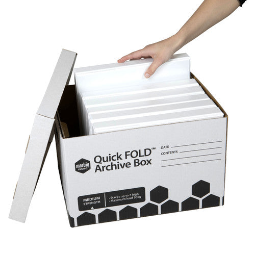 Hand loading white ring binders into an open Marbig Quick FOLD archive box with the lid resting against the side