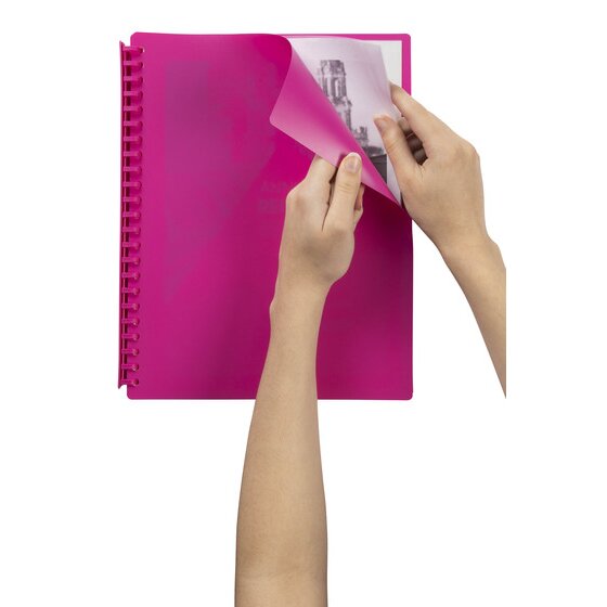 Two hands lifting the pink cover of a Marbig display book to show a printed page with a black and white photo in the first pocket