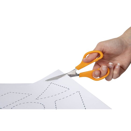 Hand holding orange handled Marbig scissors cutting along a dotted outline on a sheet of white paper
