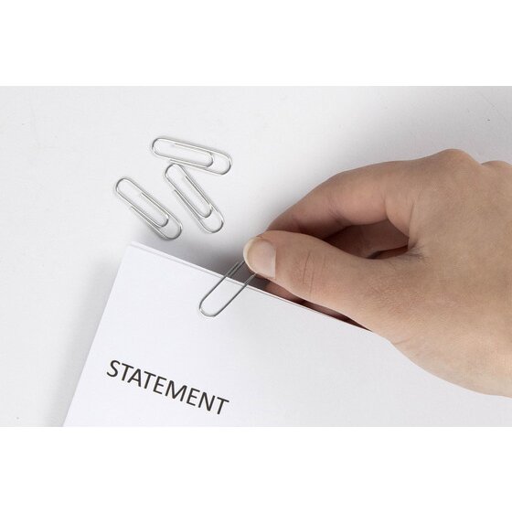 Fingers pushing a small silver Marbig paper clip onto a printed statement, two more clips resting on the white desk