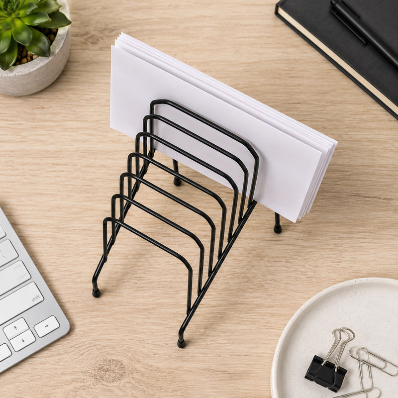 Top view of the Marbig Step File Wire Organiser Small Black holding documents on a timber desktop beside a laptop, stationery and office accessories, highlighting the compact six slot design and space saving layout.