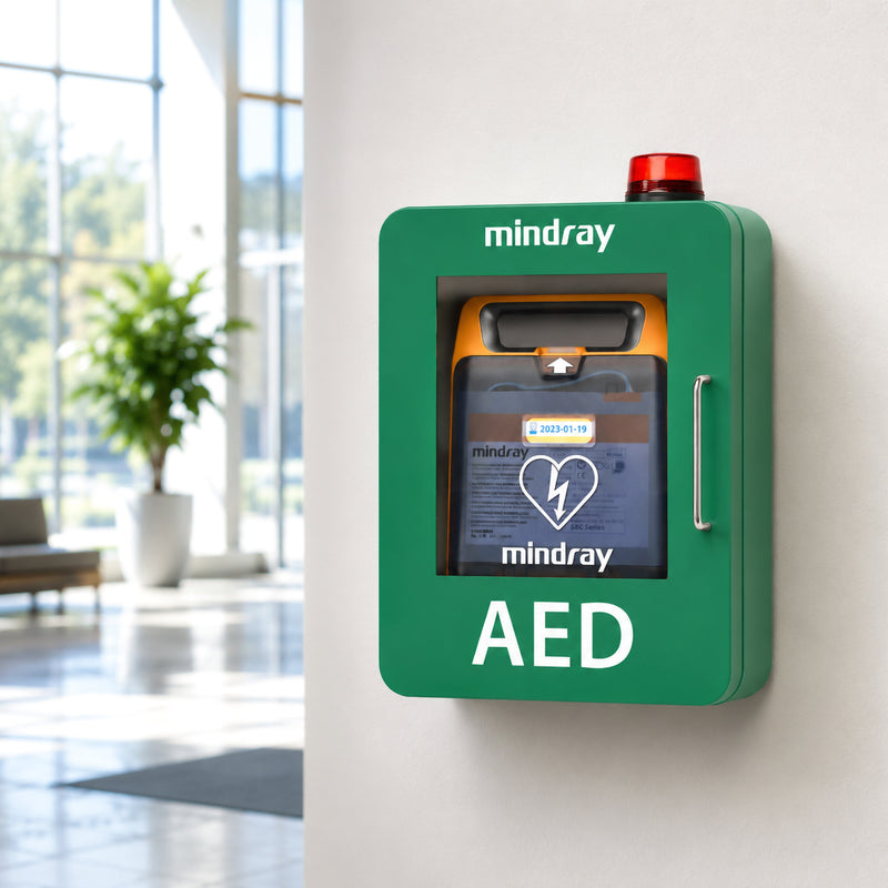 Mindray C2 Fully Automatic Defibrillator stored inside a clearly marked green wall mounted AED cabinet with a warning beacon, illustrating visible and accessible placement within a modern public or commercial facility.