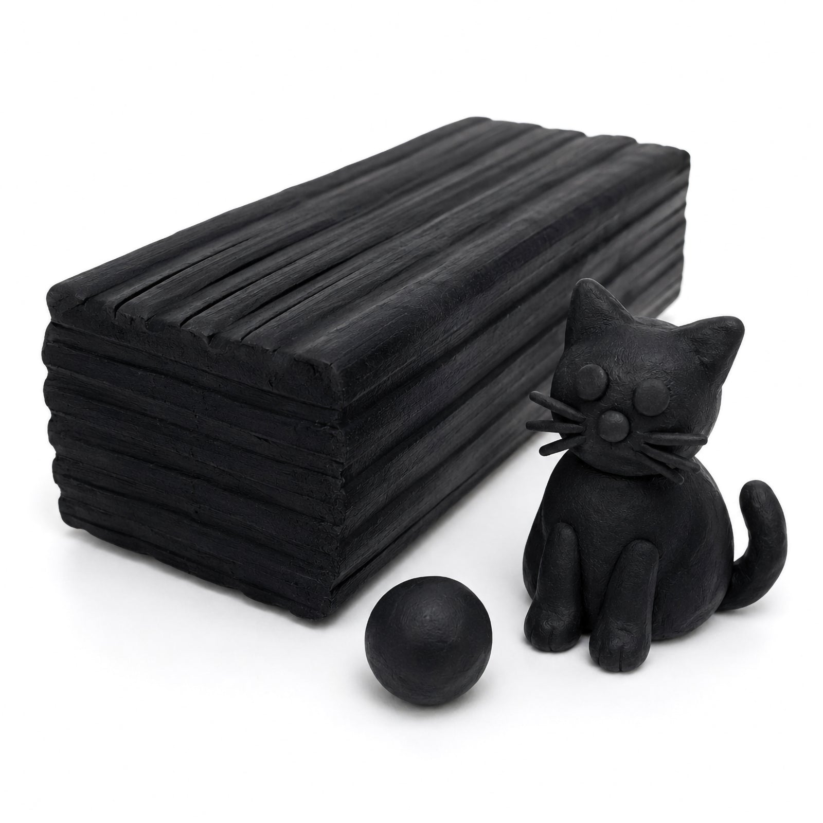 Close-up studio image of Educational Colours black modelling clay block with a handmade black cat sculpture and clay ball on a clean white background highlighting texture and sculpting detail.